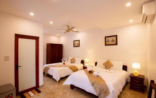a bedroom with two beds and a ceiling fan at Lys Homestay in Ninh Binh