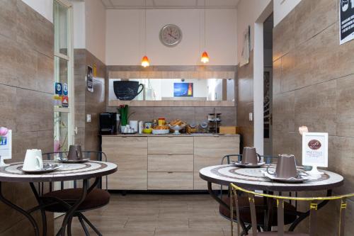 - deux tables dans une pièce avec cuisine dans l'établissement Prestige B&B, à Catane