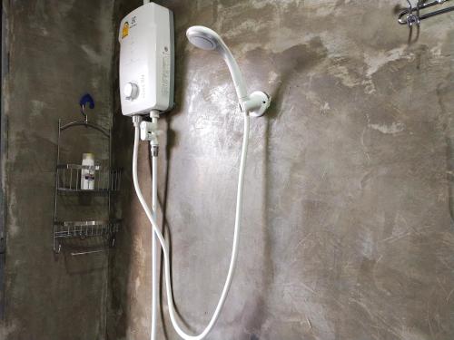 a shower in a bathroom with a white hose at Punsuk in Khon Kaen