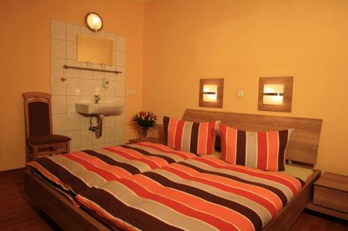ein Schlafzimmer mit einem großen Bett und einem Waschbecken in der Unterkunft Hotel Voxtrup in Osnabrück