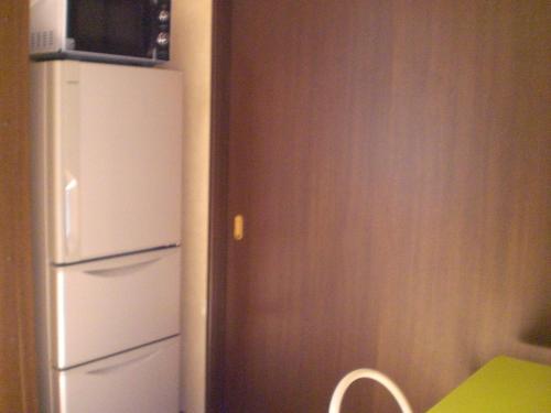 a kitchen with a white refrigerator and a microwave at Marina bay Numazu マリーナベイ沼津 BBQ可 in Numazu