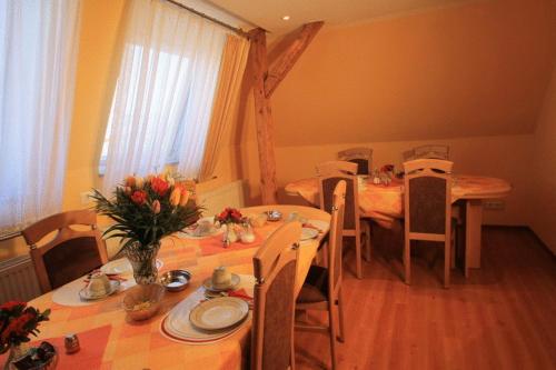 ein Esszimmer mit Tischen und Stühlen mit Blumen in der Unterkunft Hotel Voxtrup in Osnabrück