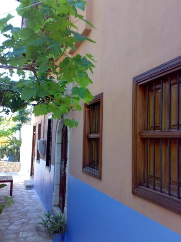 a building with two windows and a tree at Karnayo in Meyisti