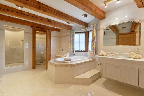 une grande salle de bain avec une baignoire et un lavabo dans l'établissement Ferienresidenz Florian, à St. Johann in Tirol