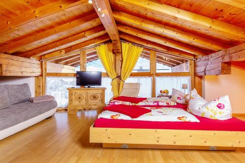 une chambre avec un lit dans une pièce avec des plafonds en bois dans l'établissement Ferienresidenz Florian, à St. Johann in Tirol