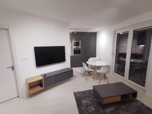 een woonkamer met een flatscreen-tv aan de muur bij Crni bor in Divčibare