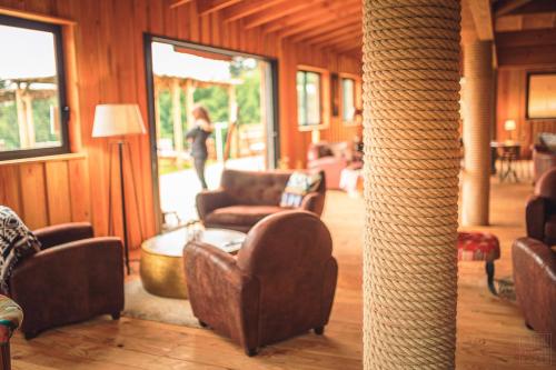 a woman walking through a living room with couches and a table at Domaine de la Vitarelle Glamping in Villanière