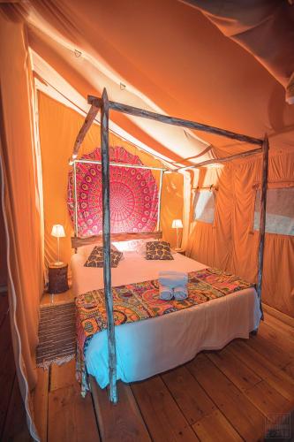 a bedroom with a bed in a tent at Domaine de la Vitarelle Glamping in Villanière