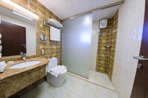 a bathroom with a toilet and a sink and a shower at Taj Al Worood in Jeddah