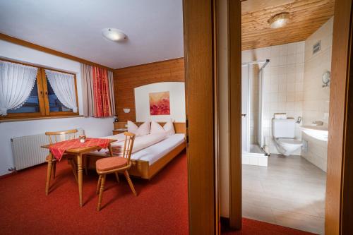 カップルにあるLandhaus Sailerのベッドルーム1室(ベッド1台、テーブル付)、バスルーム1室が備わります。