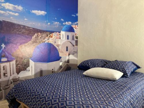 une chambre avec un lit avec un tableau sur le mur dans l'établissement Les Petites Cyclades, à Biarritz