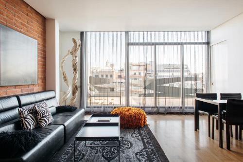 a living room filled with furniture and a large window at Suites Avenue in Barcelona