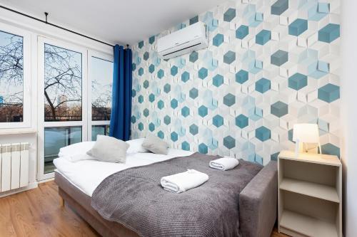 a bedroom with a bed and a geometric wall at Apartments Pańska Warsaw by Renters in Warsaw