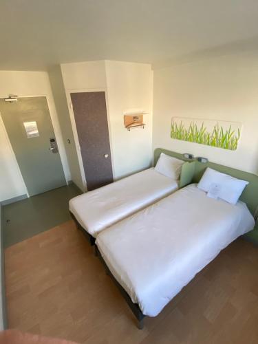 a bedroom with two beds in a room at ibis Budget Caen Centre Gare in Caen