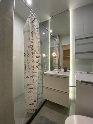 a bathroom with a shower with writing on the wall at Стильная, компактная квартира. in Kyiv