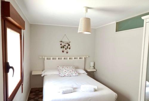 sypialnia z białym łóżkiem i 2 ręcznikami w obiekcie Apartamento Rural La Cascada de Calmarza w mieście Calmarza