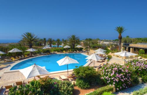 uma vista panorâmica para uma piscina do resort com guarda-sóis em Hotel Ta' Cenc & Spa em Sannat