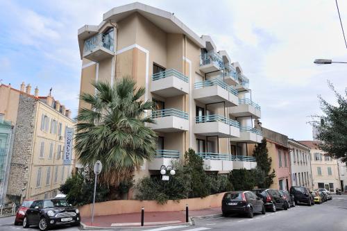 a building with a clock on the side of it at Residhotel Les Coralynes in Cannes