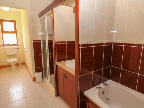 a bathroom with a tub and a sink and a toilet at Dooneen in Skibbereen