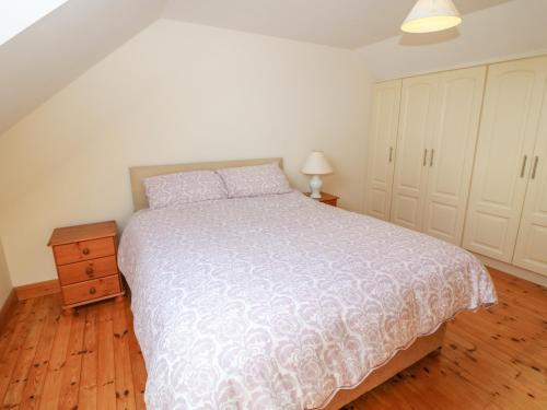 a bedroom with a large bed and a wooden floor at Dooneen in Skibbereen