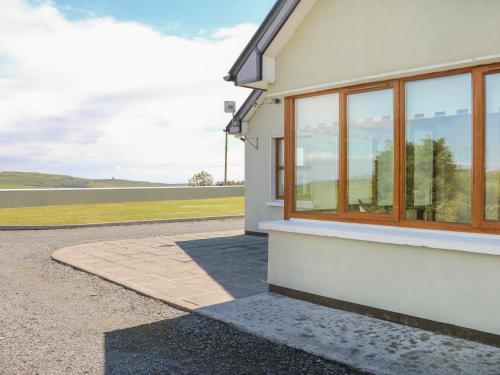 a white building with windows and a body of water at Dooneen in Skibbereen