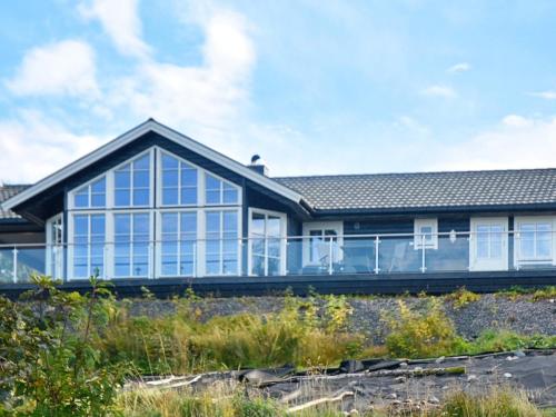 una casa con ventanas grandes en un lateral en 8 person holiday home in TORVIKBUKT, en Torvikbukt