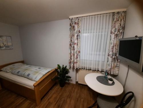 a small bedroom with a bed and a table at Chambtaler Hof in Runding