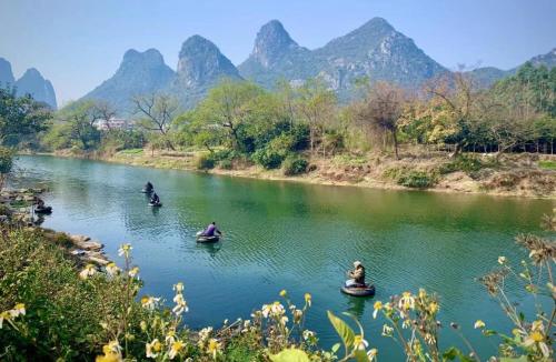 a group of people in boats on a river with mountains at Secret Courtyard Resort Hotel in Guilin