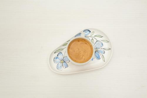 a cup of coffee on a plate with blue flowers at Hotel Ramos Mejía in Mar del Plata