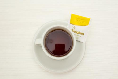 a cup of coffee on a plate with a packet of tea at Hotel Ramos Mejía in Mar del Plata
