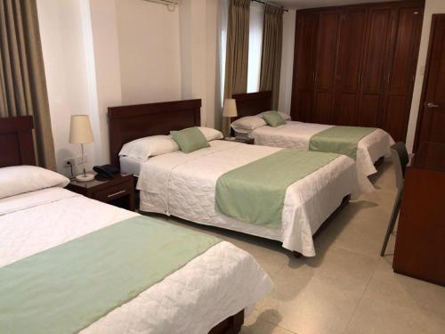 A bed or beds in a room at Colon Plaza Hotel