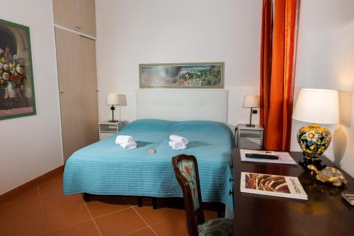 una camera con letto blu e scrivania con scrivania di Casa Linnea Vacanze a Roma