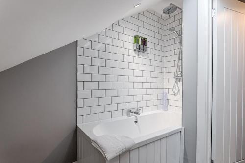 baño con lavabo y pared de azulejos blancos en Murrays Nest #3 - TV in Every Bedroom!, en Llanelli