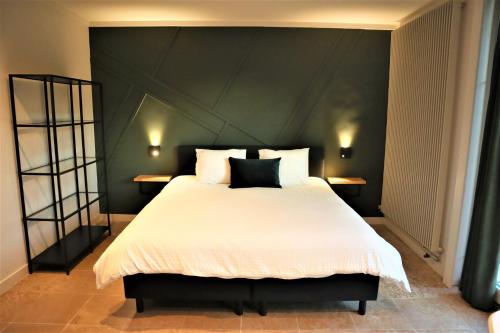 een slaapkamer met een groot bed met een zwart hoofdeinde bij B&B Fago in Brugge