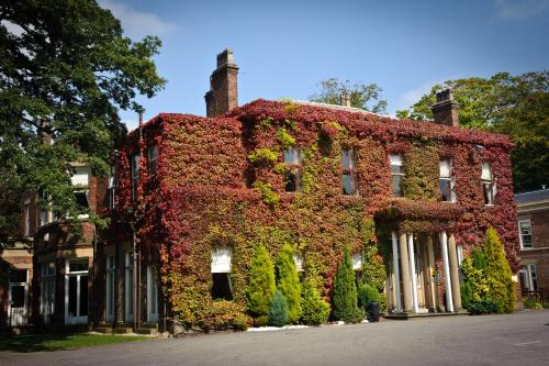 a building covered in ivy on a street at Farington Lodge Hotel in Preston