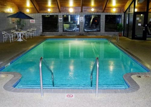 a large swimming pool in a hotel room at AmericInn by Wyndham Grimes in Grimes