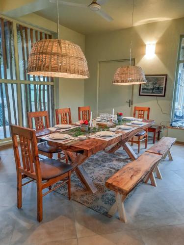 a dining room with a wooden table and chairs at Seclude Palampur in Pālampur