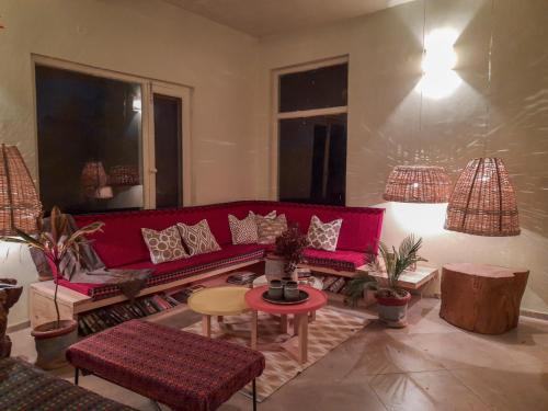a living room with a red couch and a table at Seclude Palampur in Pālampur