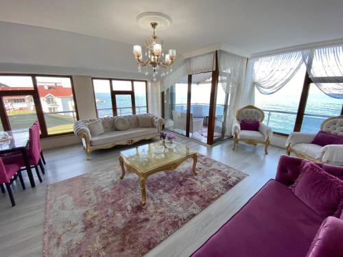 ein Wohnzimmer mit lilafarbenen Möbeln und einem Kronleuchter in der Unterkunft Trabzon Seaside in Trabzon