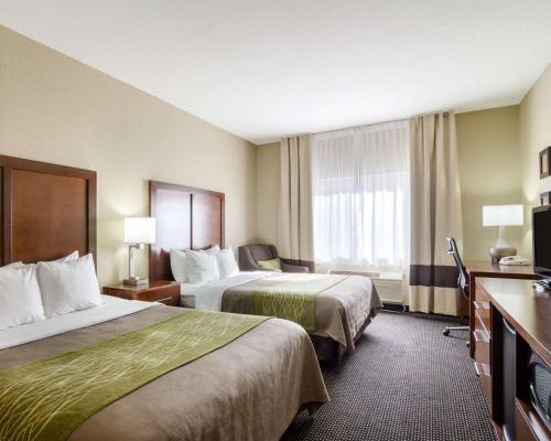 um quarto de hotel com duas camas e uma televisão em Comfort Inn em Garden City