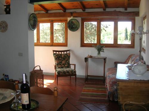 uma sala de estar com um sofá, uma cadeira e janelas em Poggio Borgoni em Mercatale Val Di Pesa