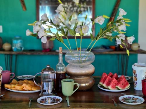 a table topped with plates of fruit and a vase with watermelon at Casa Awakening in El Cuyo