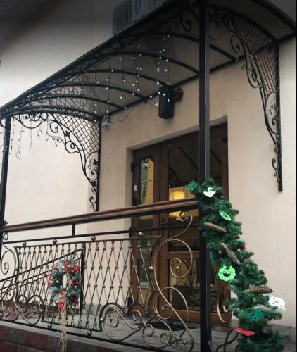 a balcony with a wrought iron railing with a christmas tree at Malva in Lviv