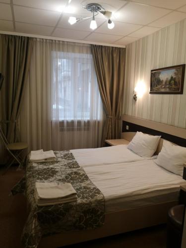 a bedroom with a large bed and a window at Hotel Voyage in Kharkiv