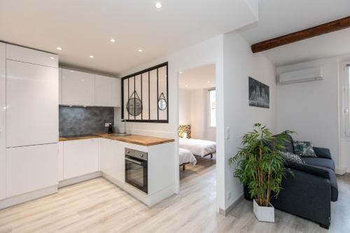 une cuisine et un salon avec un canapé et une table dans l'établissement Le Forville : 400m Palais, Calme, Clim, à Cannes