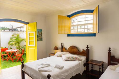 a bedroom with a bed and a window and a table at Pousada Água Viva in Paraty