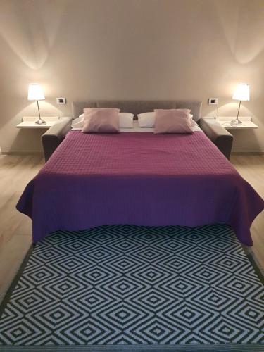 1 dormitorio con 1 cama de color púrpura y 2 lámparas en Residenza Conca Verde B&B Il monolocale, en Rogolo