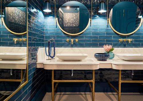 Baño con 2 lavabos y azulejos azules en Erinvale Estate Hotel & Spa, en Somerset West