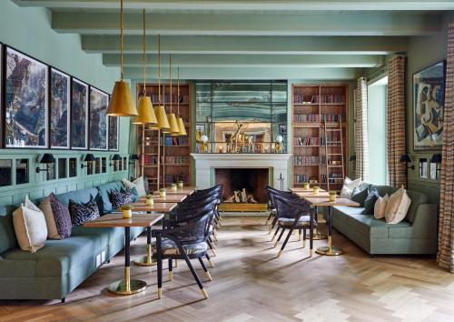 a living room with tables and chairs and a fireplace at Erinvale Estate Hotel & Spa in Somerset West