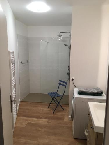 La salle de bains est pourvue d'une douche et d'une chaise bleue. dans l'établissement Nausicaa, à Trouville-sur-Mer
